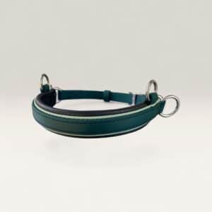 Teal leather dog collar with silver metal rings resting on a white surface.