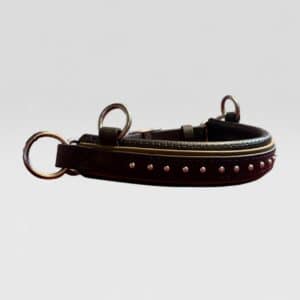 Black leather dog collar with metal studs and two buckle rings lying on its side.